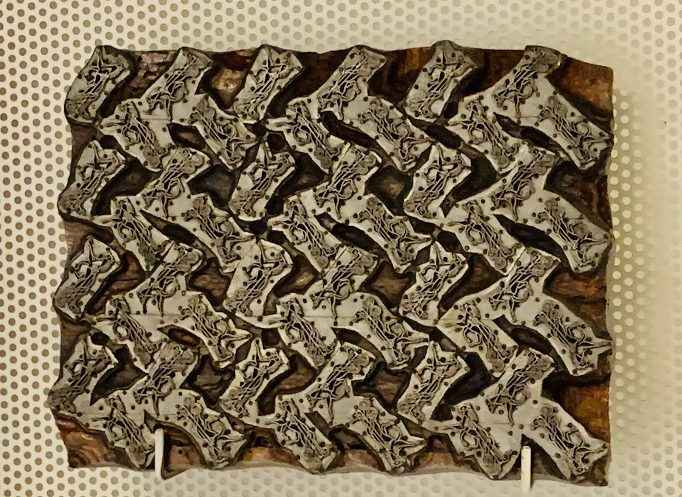 Hand-carved wooden block for printing silk on a museum display wall in Como